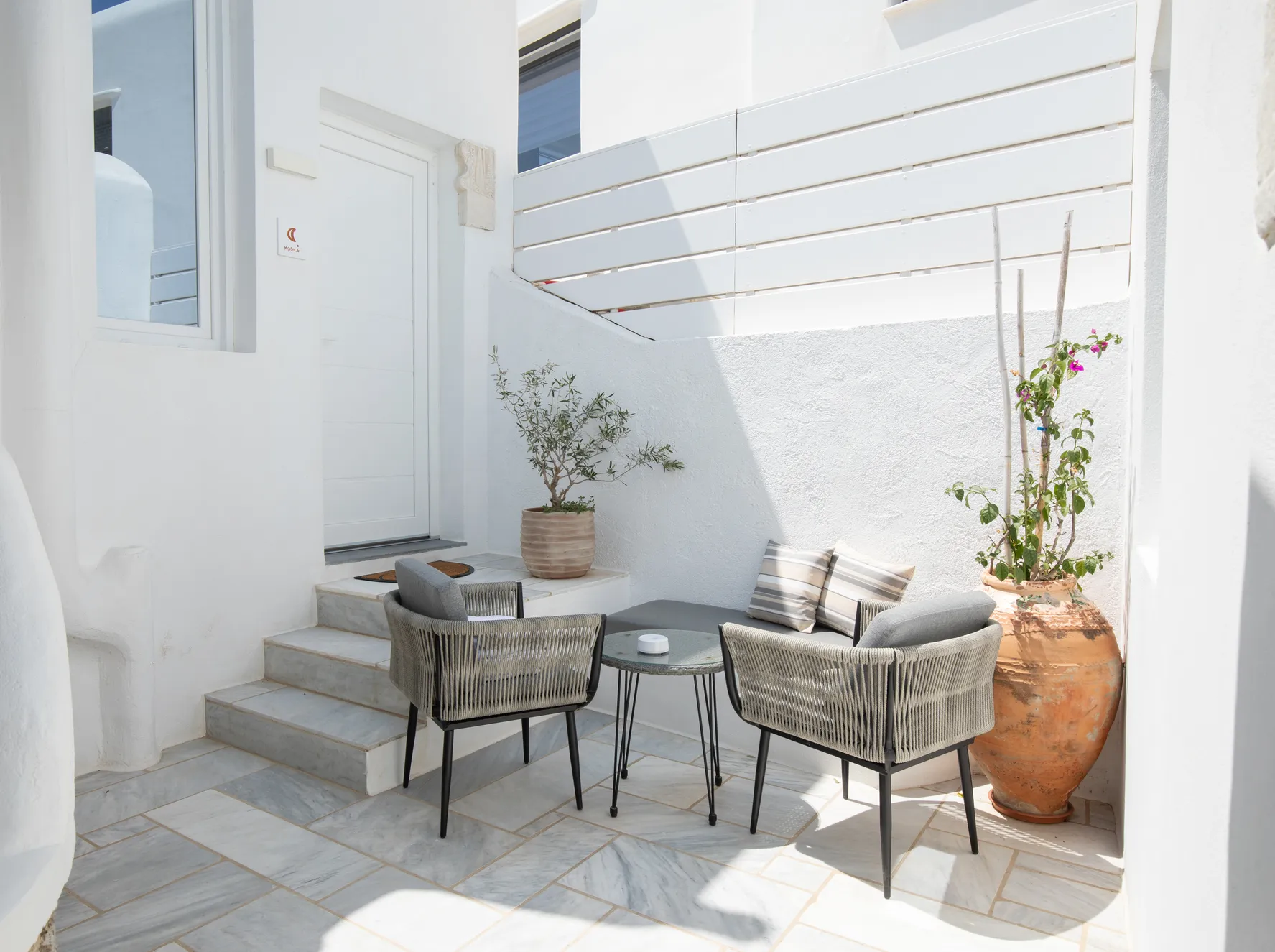 Private terrace with armchairs and terracotta pots